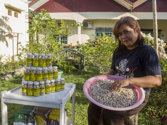 WANITA ULET: Friska Natalia Ayu bersama produk bedak basah dan lulur khas Dayak hasil olahannya.