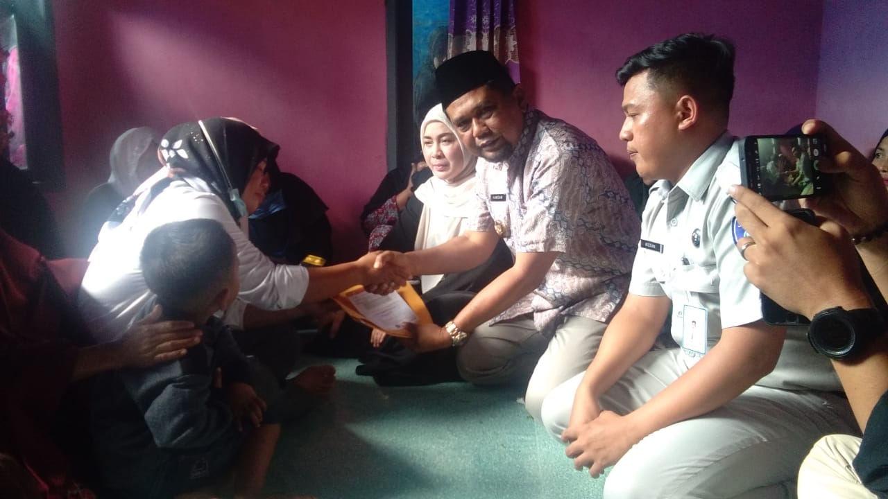 Hamdan Pongrewa (dua kanan) didampingi M Ikcsan (kanan) serah terima santunan pada ahli waris korban Ernawati (kiri) di rumah duka.