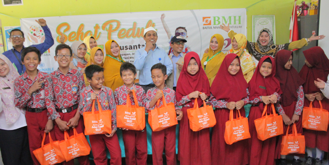GENERASI SEHAT: Mochammad Mundzir memberikan bingkisan berupa makanan sehat bergizi kepada siswa-siswi SDN 039 Desa Tani Bhakti Samboja. (foto: ahmad maki)