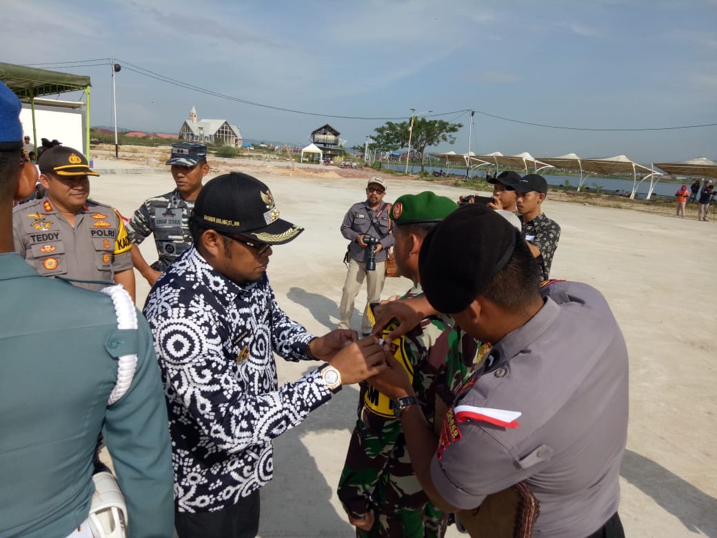 Kasmidi Bulang menyematkan pita tanda pasukan pengamanan pemilu.(Foto: Wahyu Humas)