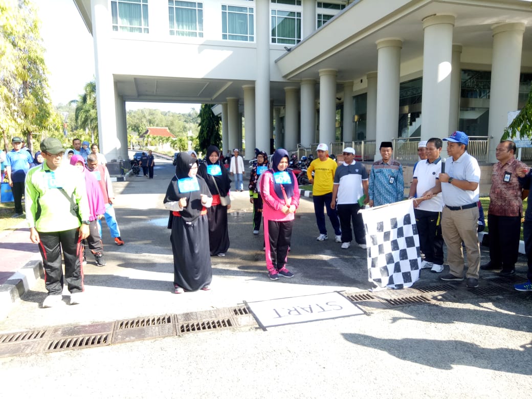 Kepala Dinkes dr Bahrani mengibarkan bendera sebelum calon haji berjalan santai dan selanjutnya dicek kesehatannya.(Foto: Wahyu Humas)