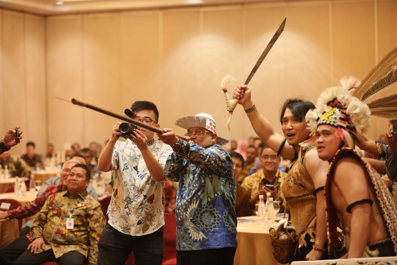 H Ismunandar secara simbolis mempraktikan menyumpit di hadapan ratusan pimpinan perusahaan perkebunan dan pertambangan.(Foto: Fuji Humas)