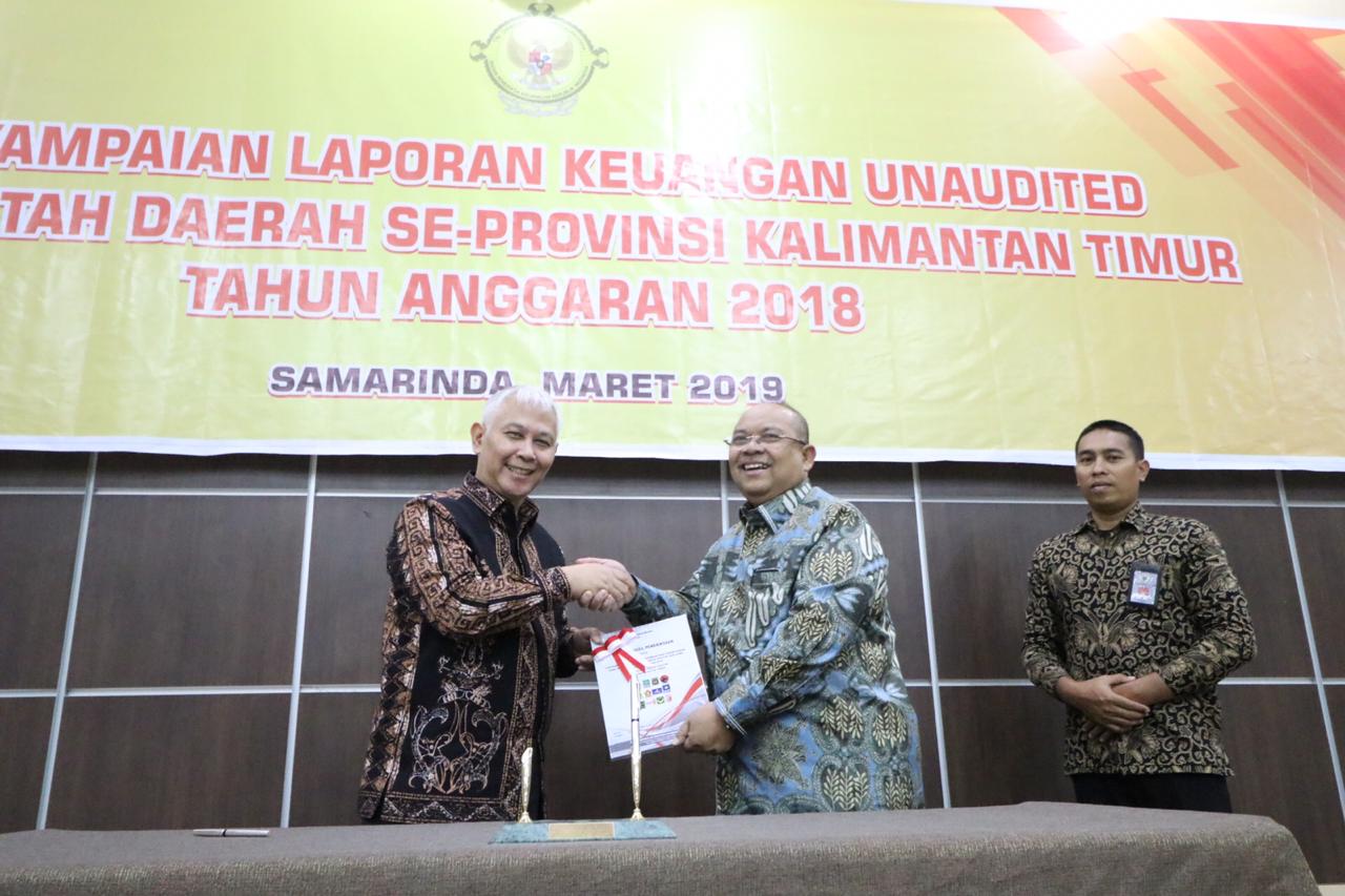 KOOPERATIF: Bupati Ismunandar menyerahkan LKPD TA 2018 Pemkab Kutim kepada Kepala BPK RI Perwakilan Kaltim Cornell Syarief Prawiradiningrat. Gubernur Kaltim Isran Noor juga turut hadir dan melakukan penandatanganan berita acara. Kegiatan ditutup dengan se