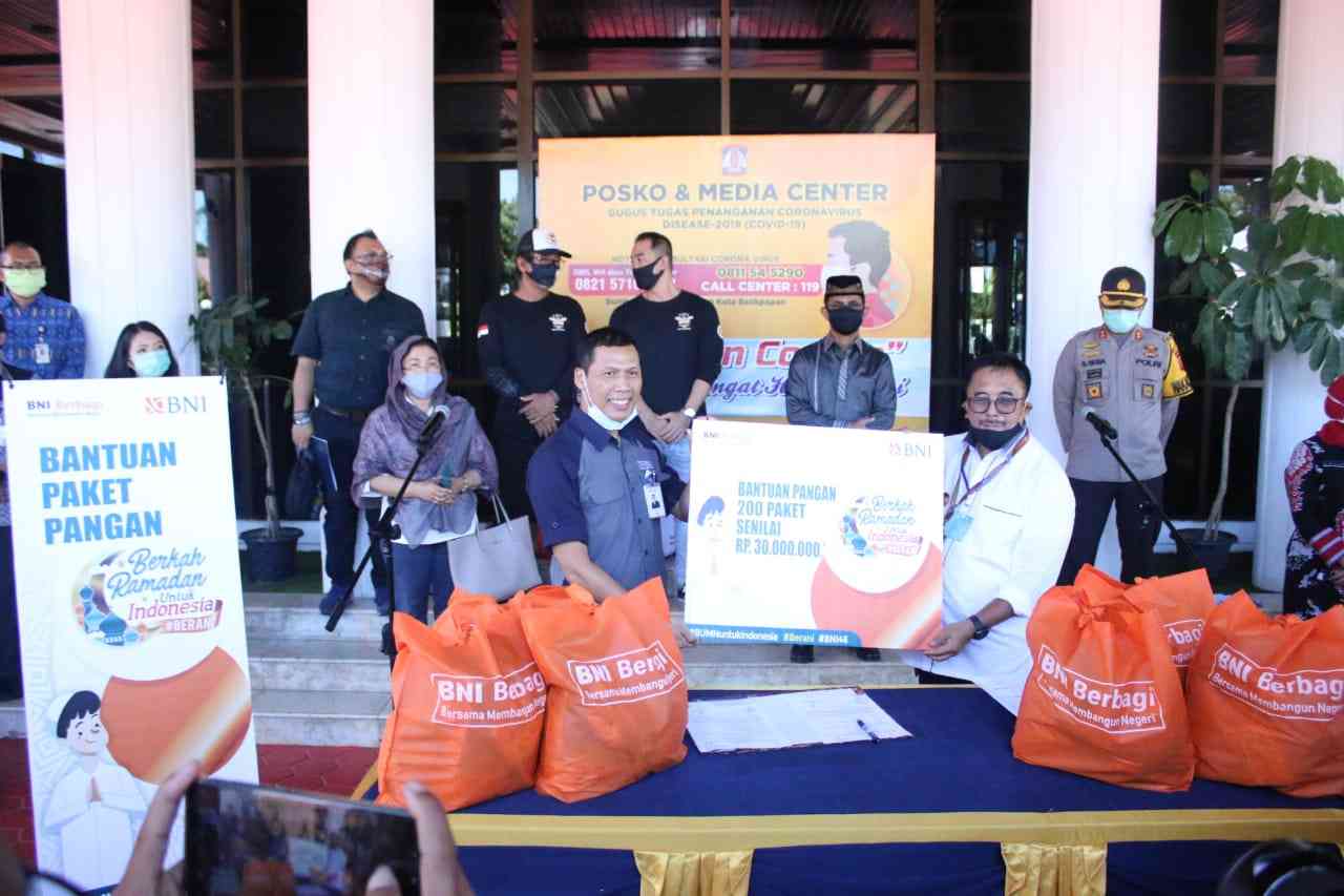 Bintara (kiri) menyerahkan simbolis bantuan kepada Rizal Effendi berupa paket pangan untuk warga terdampak di Posko dan Media Center Pemkot Balikpapan, Jumat (8/5).