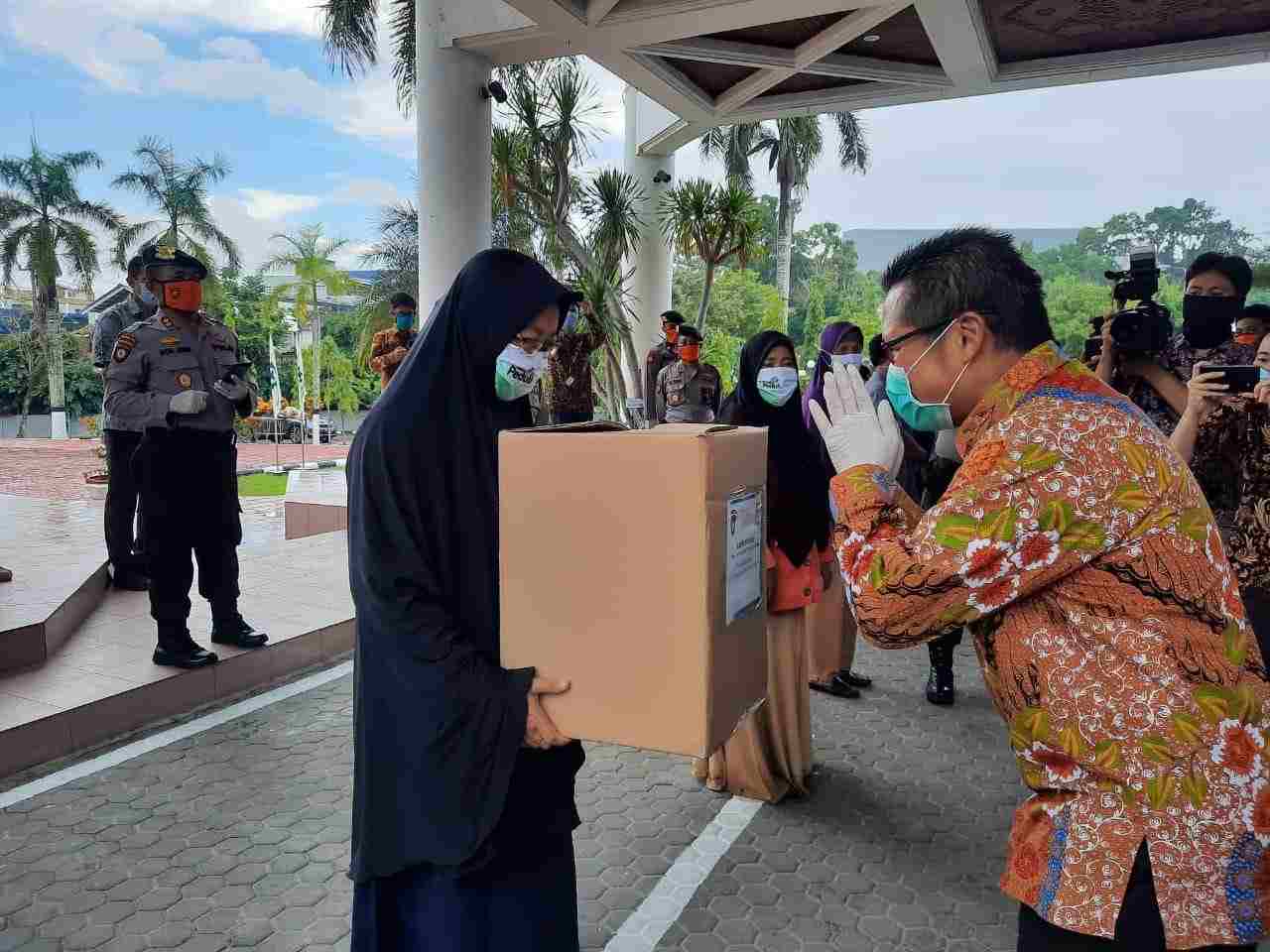 BENTUK KEPEDULIAN: Sigit Witjaksono (kanan) menyerahkan secara simbolis bantuan paket sembako kepada salah satu penerima manfaat.