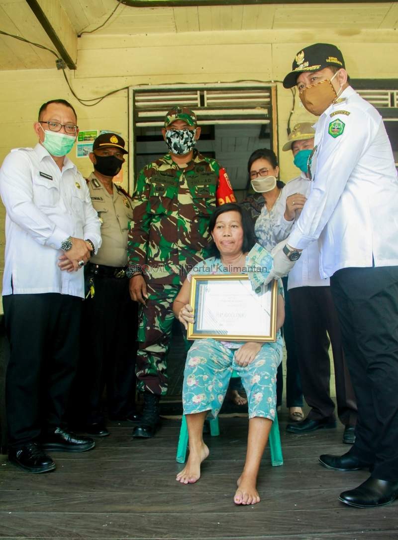 JADI PERHATIAN: Bupati Bonifasius Belawan Geh menyerahkan BLT dana kampung kepada warga miskin.