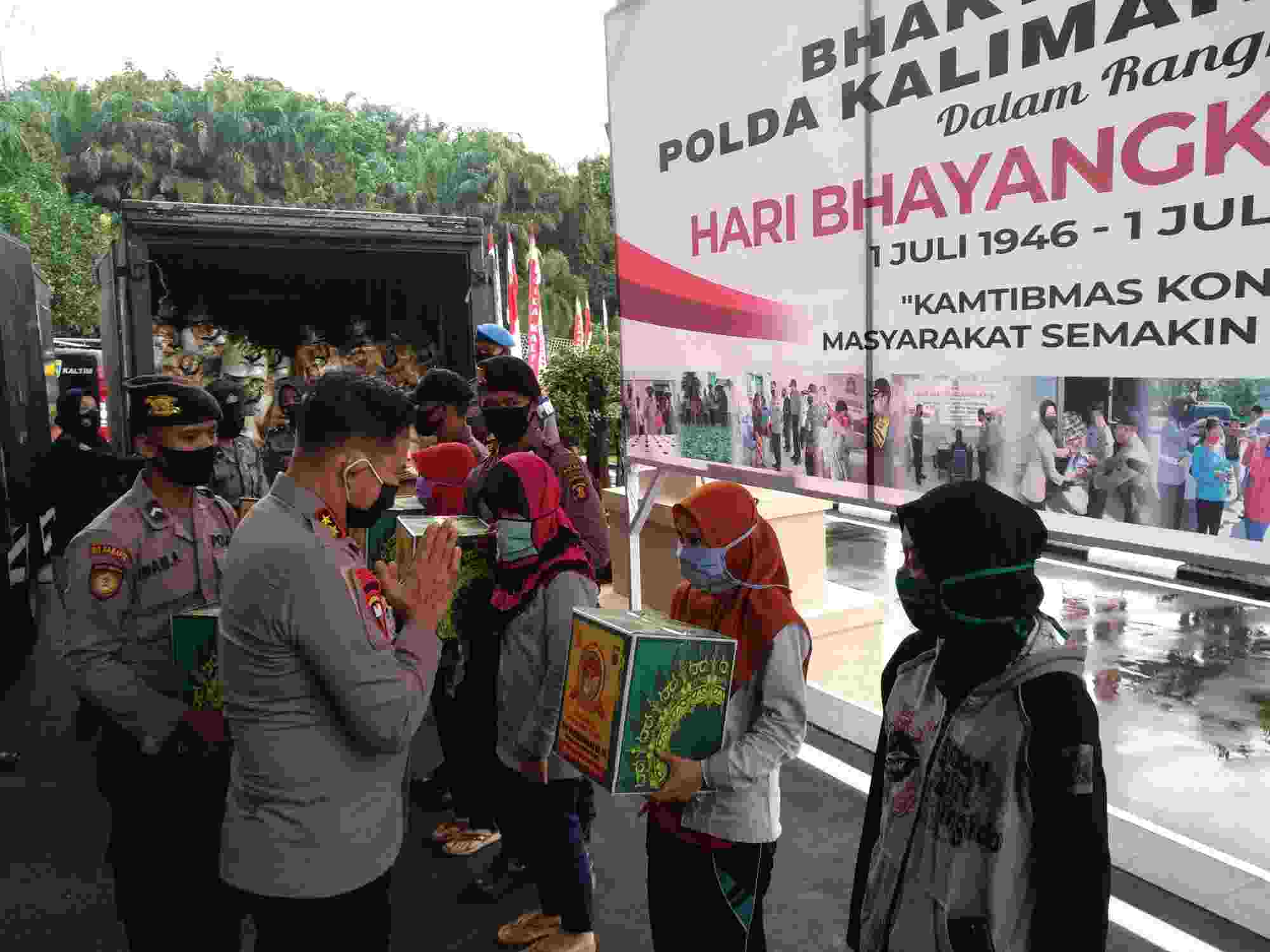 Kapolda Kaltim Irjen Pol Muktiono menyerahkan paket sembako secara simbolis kepada warga. (foto: wawan/prokal)