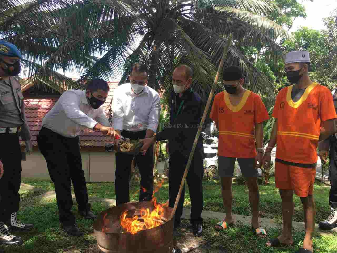 DIMUSNAHKAN : Kasubdit III Diresnarkoba Polda Kaltim Roni Bonic, bersama tim dari Kejaksaan Balikpapan melakukan pemusnahan barang bukti ganja seberat 965 gram ke dalam drum bekas yang ada di halaman Mapolda Kaltim, Senin (29/3).
