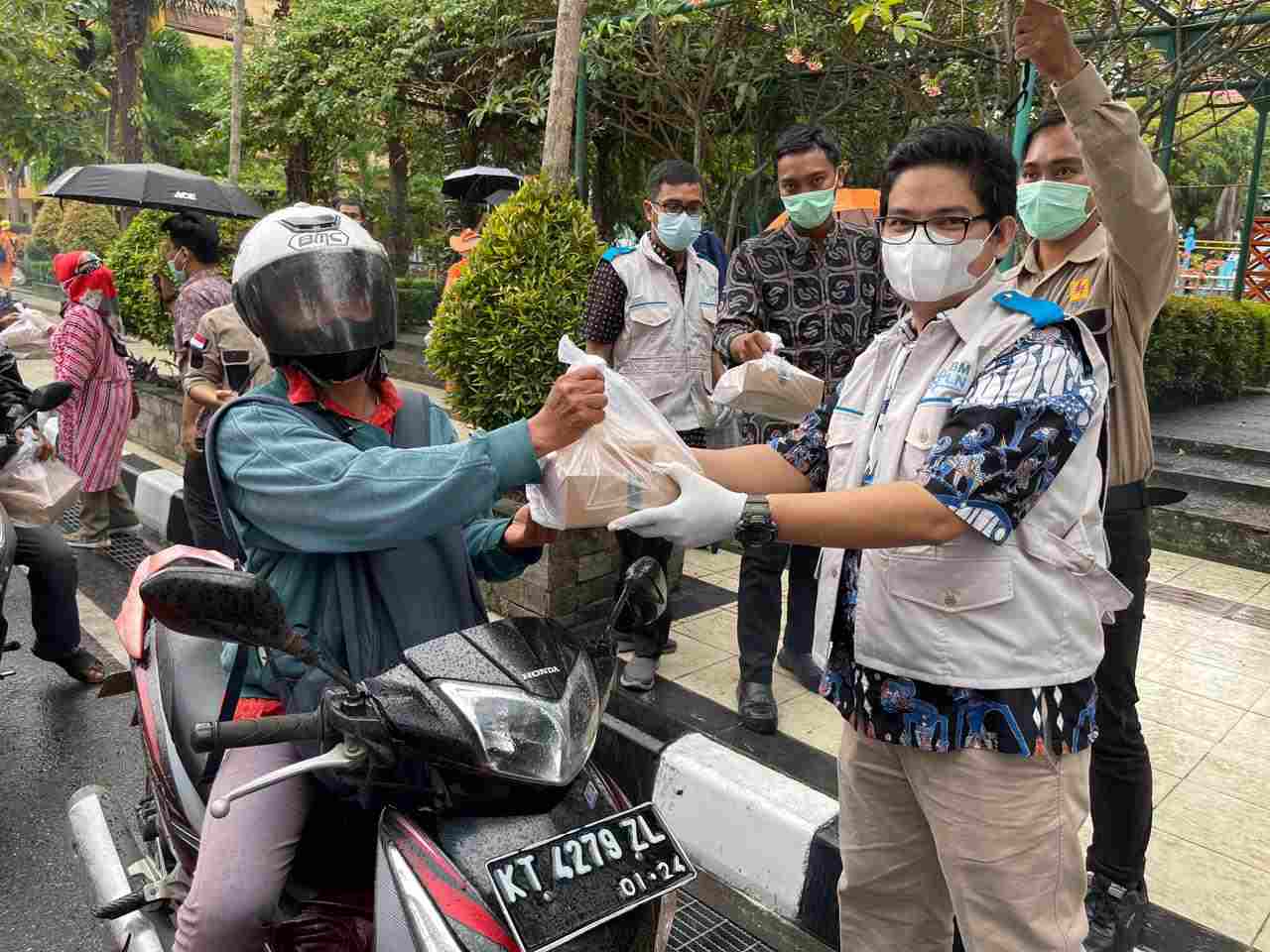 BENTUK KEPEDULIAN: Albert Sitompul (kanan) saat membagikan takjil kepada para pengendara dan masyarakat yang melintasi kawasan taman Bekapai Jumat (7/5). Maya Albert Sitompul (lima kiri, berkacamata) saat mengunjungi salah satu panti asuhan penerima bantu