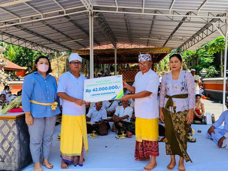 Kepala Kantor Cabang BPJS Ketenagakerjaan Balikpapan I Nyoman Hary Sujana (dua kiri) menyerahkan santunan kepada ahli waris secara simbolis didampingi Ketua PHDI Balikpapan I Nengah Kayur Wydiartana.