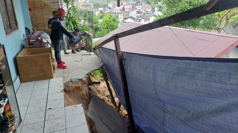 Seorang warga menunjukkan titik longsor di RT 14, Kelurahan Gunung Sari Ulu, Balikpapan Tengah. Hujan deras yang turun sejak Senin (22/5) membuat sejumlah titik di Balikpapan mengalami banjir dan longsor. (Foto : Dokumenatsi Info Bencana)