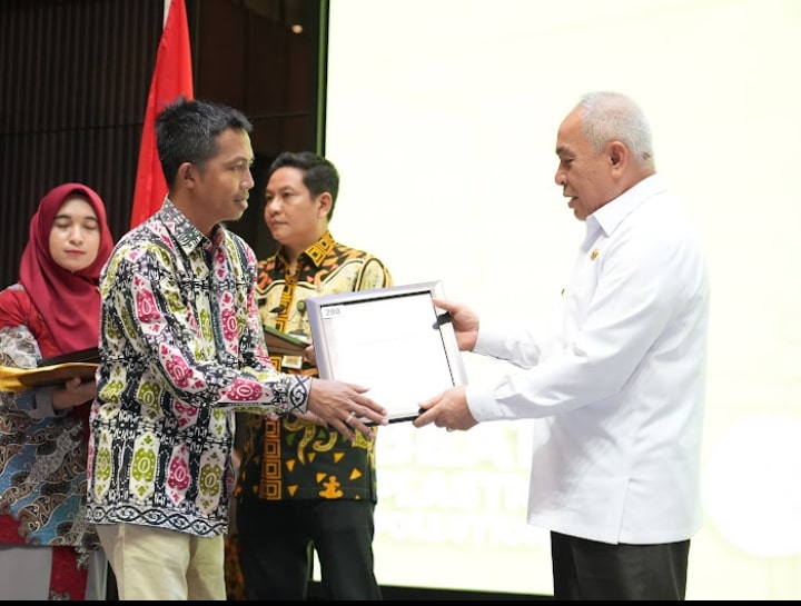 APRESIASI: Asisten CSR PT WKP Zakaria menerima plakat proper hijau dari Isran Noor.