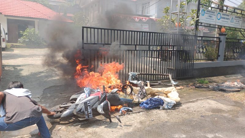 Warga berusaha memadamkan api yang membakar motor bernopol KT 4484 ZS. (Foto : Istimewa)