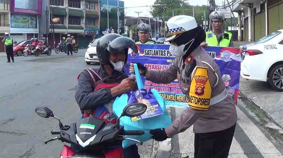 Kompol Ropiyani memberikan reward alias apresiasi kepada pengendara yang tertib berlalu lintas. (Foto : Erik Alfian/Prokal.co)