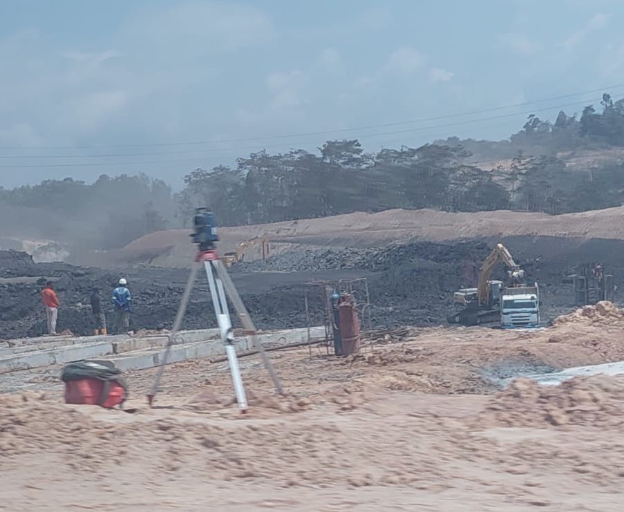 Ekskavator sedang memasukan batu bara ke dalam dump truk di proyek jalan tol segmen Karang Joang-KKT. (Istimewa)