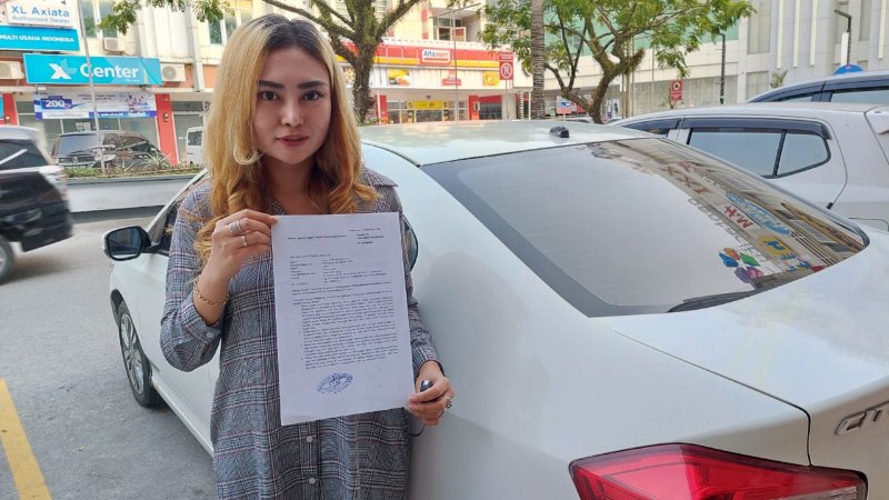 Anisa Ul Mahmudah menunjukkan surat laporan ke Polresta Balikpapan. (Foto : Erik Alfian/Prokal.co)