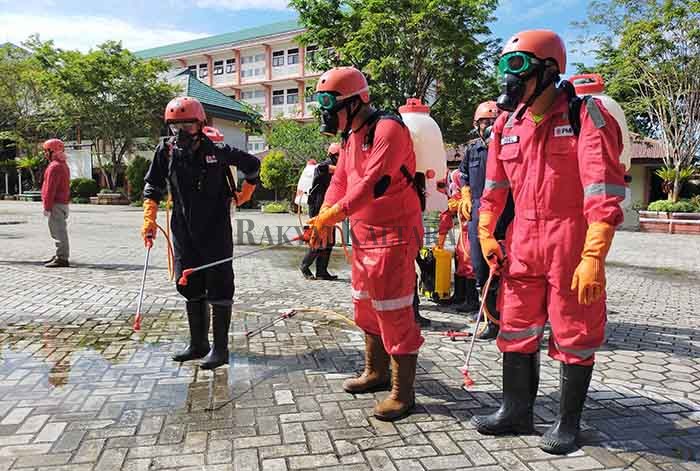 CEGAH PENYEBARAN COVID-19: Petugas PMI Cabang Tarakan bersiap melakukan penyemprotan disinfektan di SMPN 2 Tarakan, Senin (1/6).