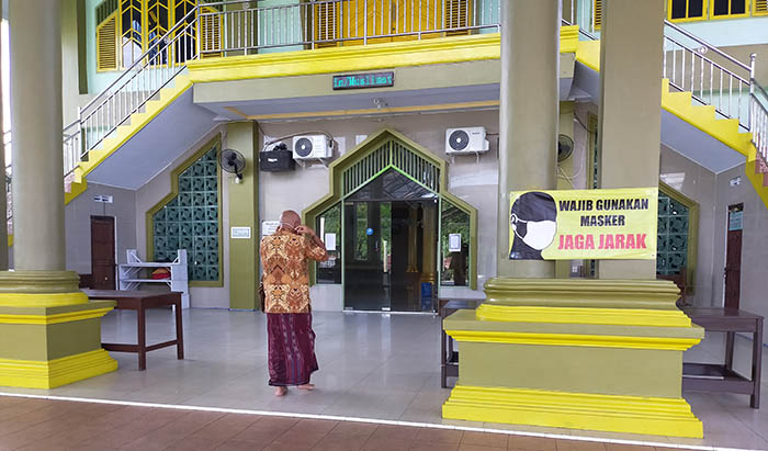 PATUHI PROTOKOL KESEHATAN: Imbauan penerapan protokol kesehatan seperti memakai masker dan menjaga jarak, dipasang di salah satu masjid di Gunung Lingkas.