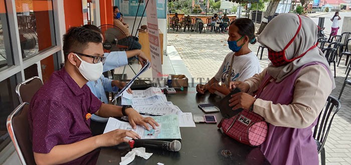 SALURKAN BLT: Masyarakat terdampak pandemi Covid-19 saat mengambil BLT.