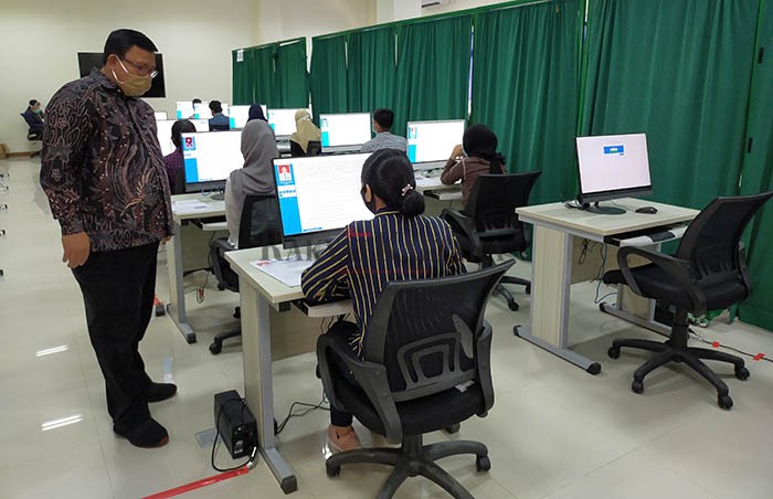 PATUHI PROTOKOL KESEHATAN: Dengan menggunakan masker, Rektor UBT Prof Adri Patton memantau UTBK di salah satu ruangan di gedung laboratorium terpadu kampus UBT, Ahad (5/7). (MUHAMMAD RAJAB/RAKYAT KALTARA)