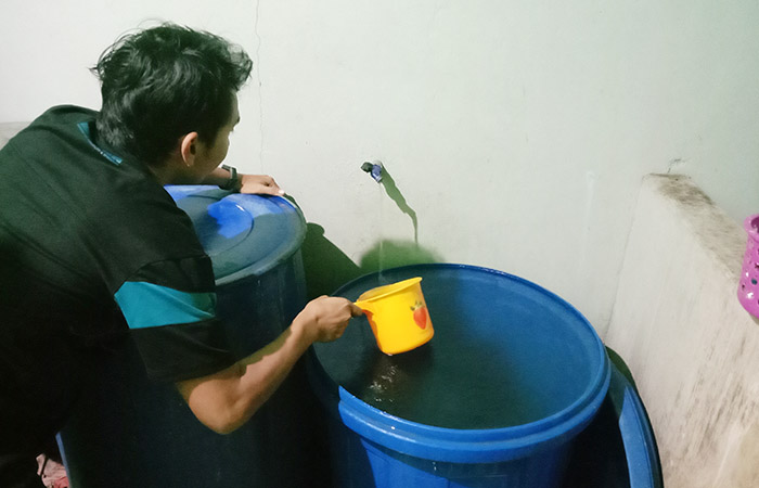 MENAMPUNG AIR: Warga kerap kesulitan air karena distribusi tidak lancar.