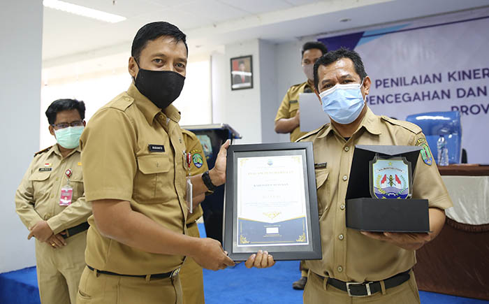 PRESTASI: Kepala Bappeda-Litbang Kaltara, Risdianto (kiri) menyerahkan plakat penghargaan kepada perwakilan Pemkab Nunukan yang menjadi juara III Penilaian Kinerja Aksi 1-4 Kabupaten/Kota Dalam KP2S Provinsi Kaltara Tahun 2020, Selasa (6/10).