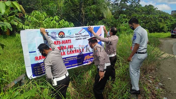 IMBAUAN: Satlantas Polres Tarakan dan Jasa Raharja memasang spanduk imbauan rawan kecelakaan, Senin (2/11).