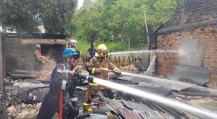 PADAMKAN SI JAGO MERAH: Petugas pemadam kebakaran saat melakukan pendinginan di rumah Longga, di Gang Uluay RT 03 Jalan Lestari, Kelurahan Karang Harapan, Tarakan Barat, Jumat (2/4).