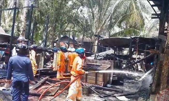 TINGGAL PUING: Petugas pemadam kebakaran memadamkan api yang menghanguskan dua unit rumah warga, Selasa pagi (28/9).
