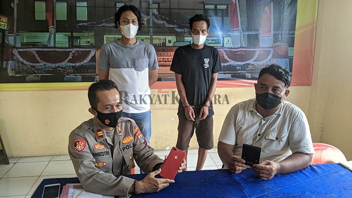 PENCURIAN: Barang bukti berupa handphone yang diambil tersangka (kaos hitam), Selasa (9/11).