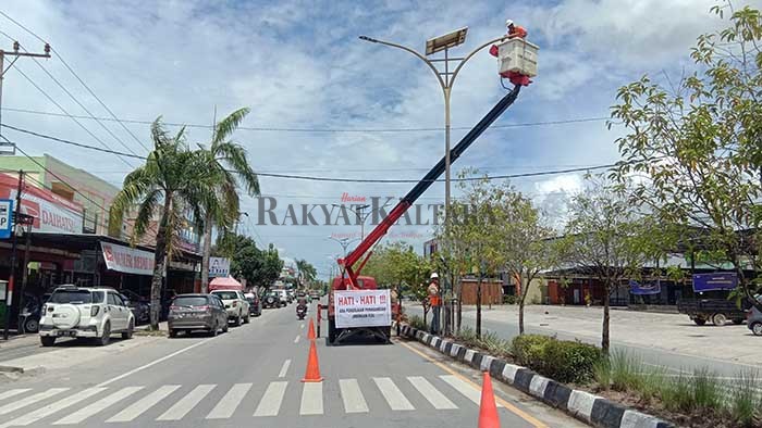 PEMASANGAN KABEL: Petugas memasang kabel PJU yang akan dikonversi dari tenaga surya ke listrik.