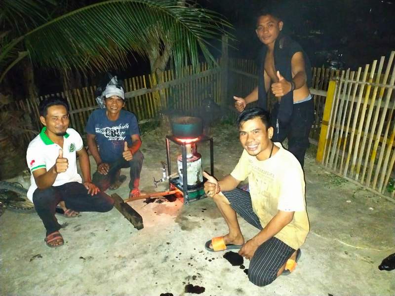 MASAK BURAS: Maskur memasak buras saat Lebaran menggunakan kompor dengan bahan bakar oli bekas. DOKUMENTASI PRIBADI