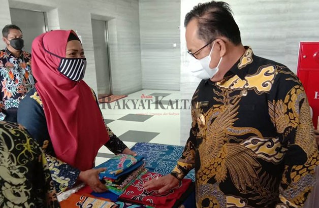 DONGKRAK PEREKONOMIAN: Wakil Bupati KTT Hendrik melihat batik khas KTT yang berada di Galeri UMKM.