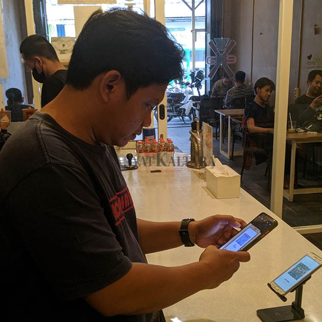 PENGGUNA QRIS: Warga di Tarakan menggunakan QRIS saat melakukan transaksi non tunai di salah satu kafe.