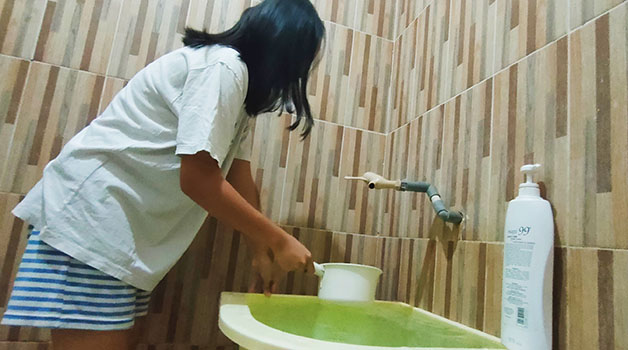 ANTISIPASI DBD: Warga terlihat menguras bak mandi untuk mengantisipasi jentik nyamuk berkembang biak.