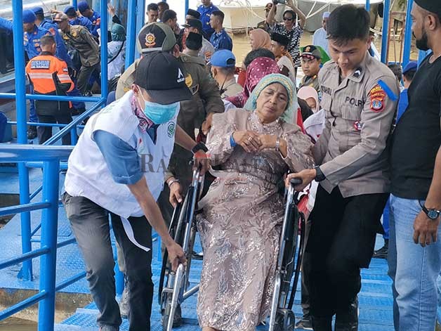 KEMBALI DARI TANAH SUCI: Jemaah haji Bulungan yang menggunakan kursi roda dibantu petugas saat tiba di Pelabuhan VIP Tanjung Selor, Kamis (13/7).