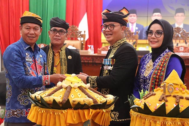 PERAYAAN HARI JADI: Bupati KTT Ibrahim Ali menyerahkan potongan tumpeng kepada Asisten I Bidang Pemerintah dan Kesejahteraan Rakyat Kaltara Datu Iqro Ramadhan, Kamis (10/8).
