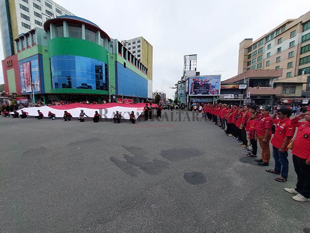 BERI PENGHORMATAN: Sebagian warga Tarakan turut andil dalam perayaan HUT ke-78 RI dengan pembentangan bendera Merah Putih di perempatan Jalan GTM, Kamis (17/8).