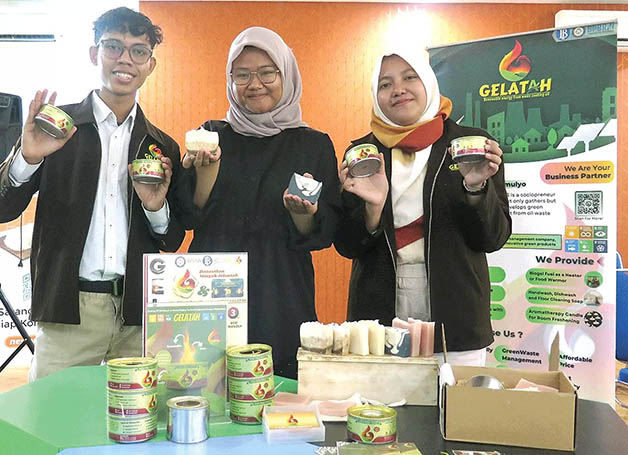 DARI LIMBAH JADI BERKAH: Dari kiri, Abdul Rohman, Kariza Makanty, dan Vita Amalia Hidayati menunjukkan beberapa produk hasil pengolahan limbah jelantah di Gedung Inkubator Bisnis Unair, Surabaya.