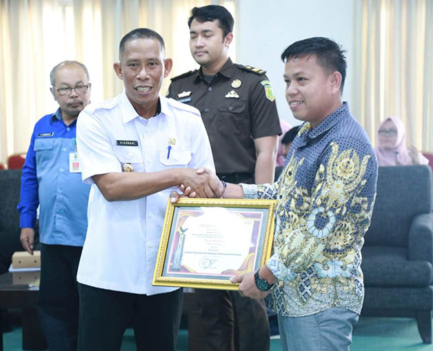 BERI PENGHARGAAN: Bupati Bulungan Syarwani (kiri) menyerahkan penghargaan bagi para wajib pajak, kemarin (26/10).