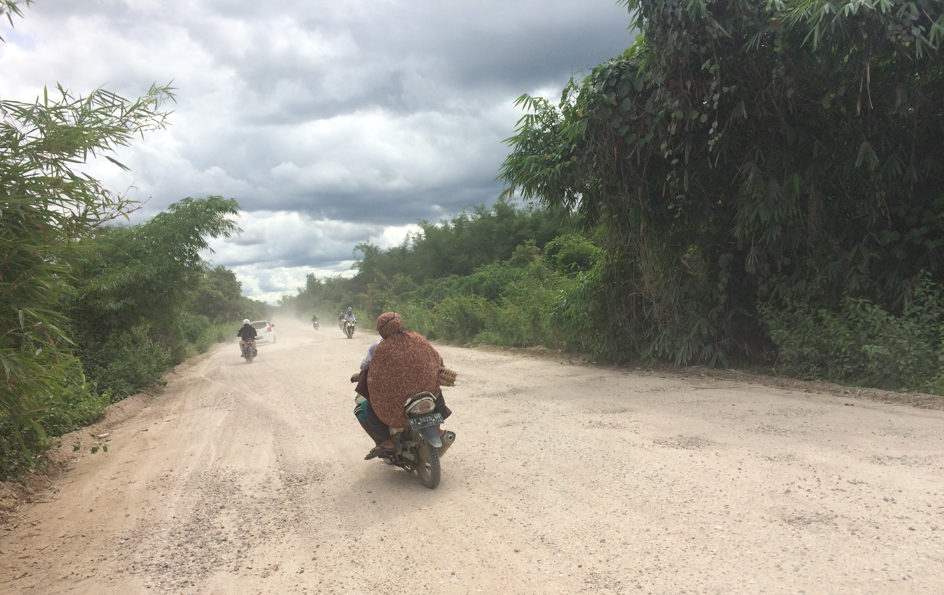 BELUM DIASPAL. Sampai sekarang pemakai jalan di jalur Sebelimbingan (Kota Bangun)-Tuana Tuha (Kenohan), terutama pemotor, harus berjibaku dengan kepulan debu tebal ketika melintas di jalur poros ke pedalaman Kukar ini. (idin/sapos)