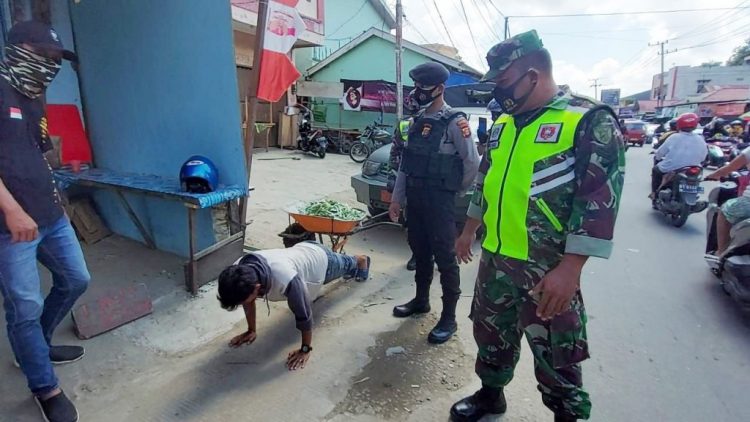 Petugas memberi sanksi kepada warga yang tak taat protokol kesehatan.
