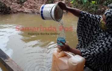 Warga menggunakan air di dalam genangan karena PDAM tak mengalir.