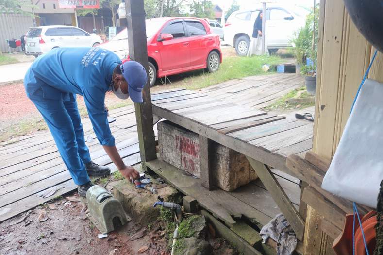 CEK: Petugas Perumdam TTB Kutim saat memeriksa alat meteran air milik salah satu pelanggan.