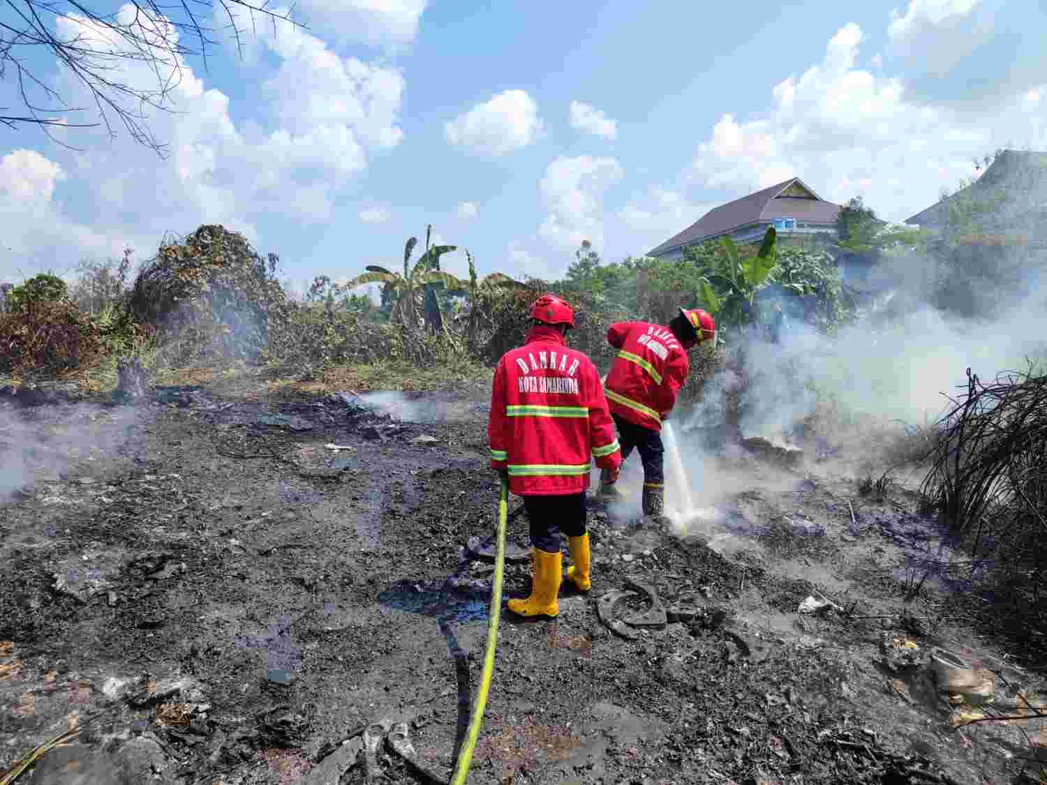 PANIK. Petugas pemadam kebakaran tengah melakukan pemadaman di sebuah lahan terbakar di Jalan Perjuangan Baru, RT 02, Kelurahan Sempaja Selatan, Kecamatan Samarinda Utara. (kis)