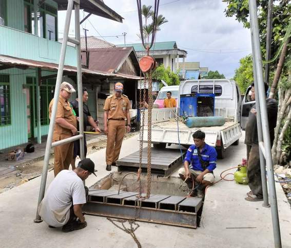 EVALUASI PEKERJAAN: Jajaran Kelurahan Sungai Keledang meninjau pembenahan besi penutup saluran parit baru yang disebabkan terlalu lebarnya manhole.