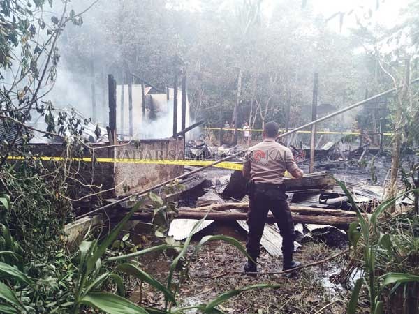 PEMADAMAN: Petugas berusaha memadamkan sisa api yang menghanguskan kediaman Melmam, Selasa (14/1).(HUMAS POLRES BARTIM)