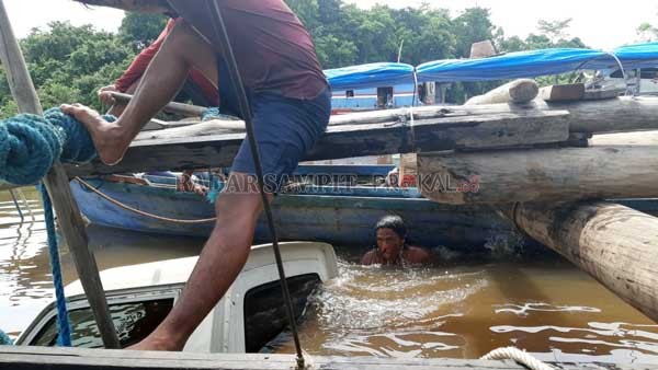 TENGGELAM : Beberapa warga saat akan mengevakuasi mobil pikap yang tercebur di Feri penyeberangan Mintin Kabupaten Pulpis.(WARGA For RADAR SAMPIT)