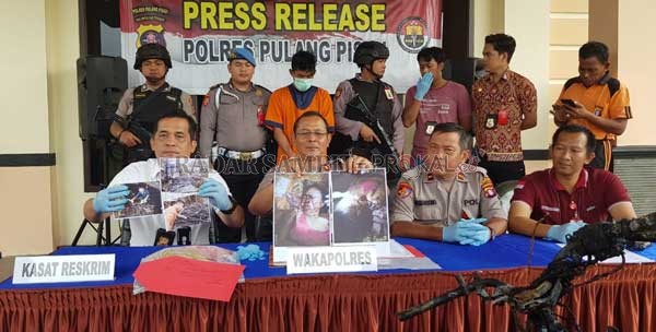 DURHAKA: Polres Pulpis melihatkan barang bukti dan foto korban yang dibunuh oleh anaknya sendiri. Pelaku hanya bisa tertunduk dengan kawalan ketat aparat bersenjata lengkap, Jumat (24/1).(ALEXANDER/RADAR SAMPIT)