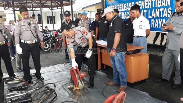 DIPOTONG : Kapolresta Palangka Raya Kombes Pol Dwi Tunggal Jaladri memotong knalpot brong hasil tindakan tegas jajarannya.(DODI/RADAR PALANGKA)